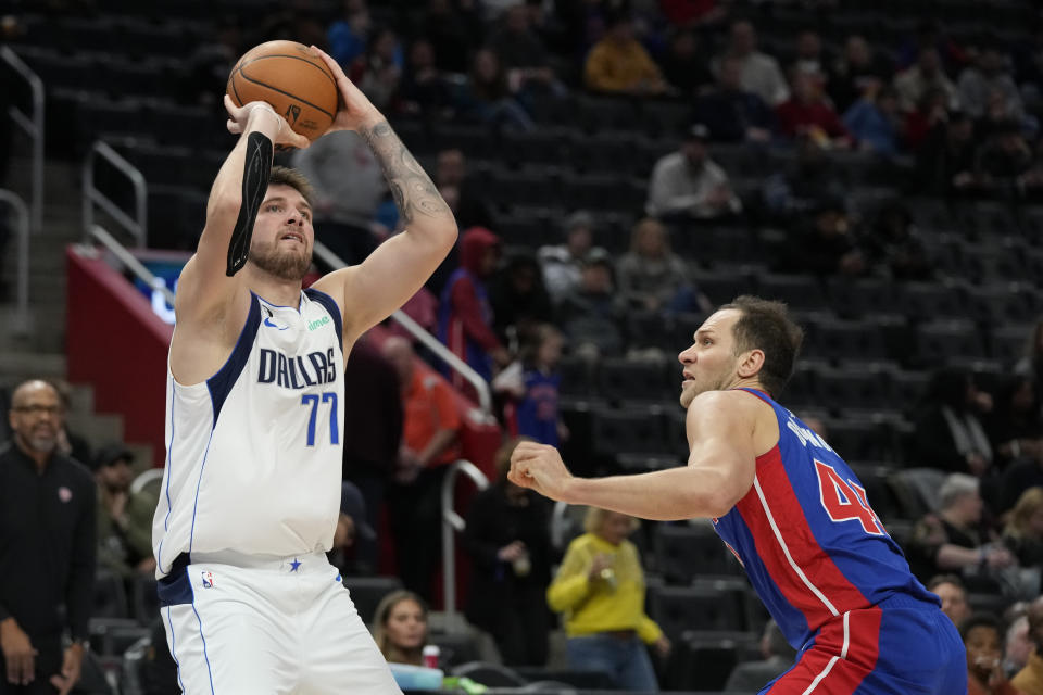 Dallas Mavericks guard Luka Doncic (77) attempts a three-point basket a Detroit Pistons forward Bojan Bogdanovic (44) defends during the second half of an NBA basketball game, Thursday, Dec. 1, 2022, in Detroit. (AP Photo/Carlos Osorio)