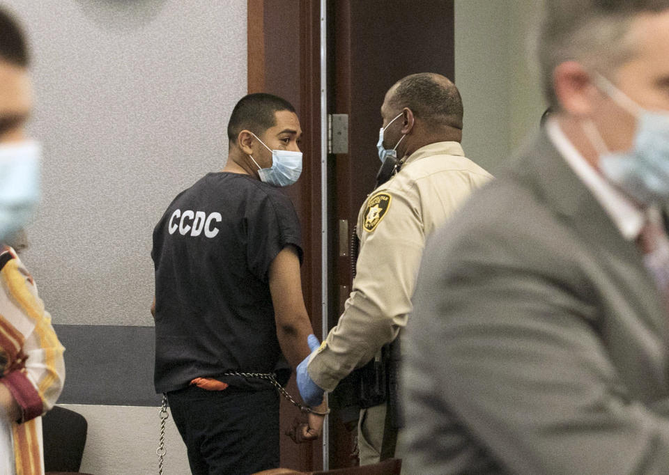 Edgar Samaniego, charged in shooting of Las Vegas police officer, is led out of the courtroom at the Regional Justice Center, Friday, June 5, 2020, in Las Vegas. A prosecutor says that a 20-year-old Las Vegas man deliberately shot and gravely wounded a police officer during a Las Vegas Strip protest over the death of George Floyd, who died May 25 after being restrained by police in Minneapolis. (Bizuayehu Tesfaye/Las Vegas Review-Journal via AP)