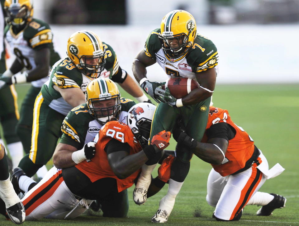 B.C. Lions Jabar Westerman, 99, and Khreem Smith, right, tackle the Edmonton Eskimos Hugh Charles, 7, as Eskimos' Kyle Koch, 61, defends, during the second quarter of CFL pre-season football action in Edmonton, Alta., Thursday, June 21, 2012. THE CANADIAN PRESS/John Ulan