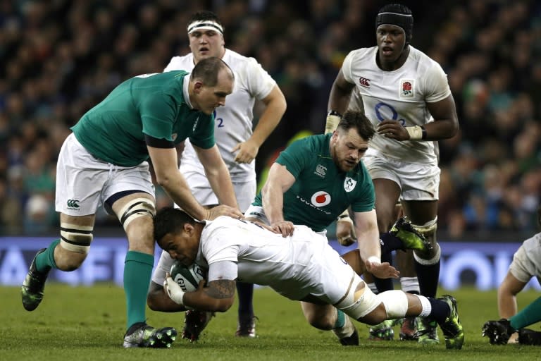 England's Nathan Hughes is tackled by Ireland's Cian Healy (C) and Devin Toner (L) during the Six Nations international rugby union match March 18, 2017