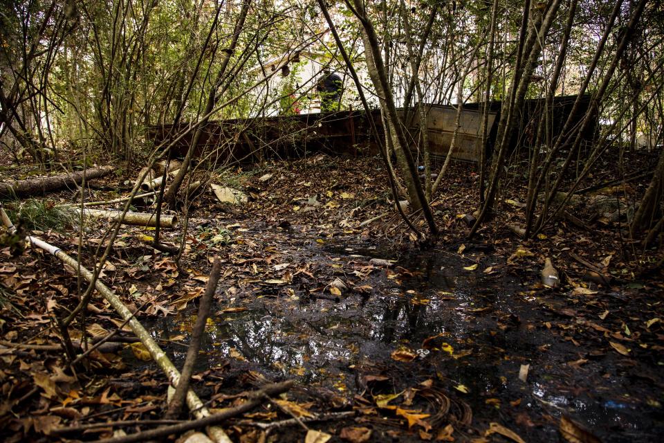 A pit of raw sewage near a cluster of trailers in a secluded community in Lowndes County, Alabama. The slim tube in the foreground pipes fresh drinking water up to the homes. (Photo: ANNA LEAH FOR HUFFPOST)