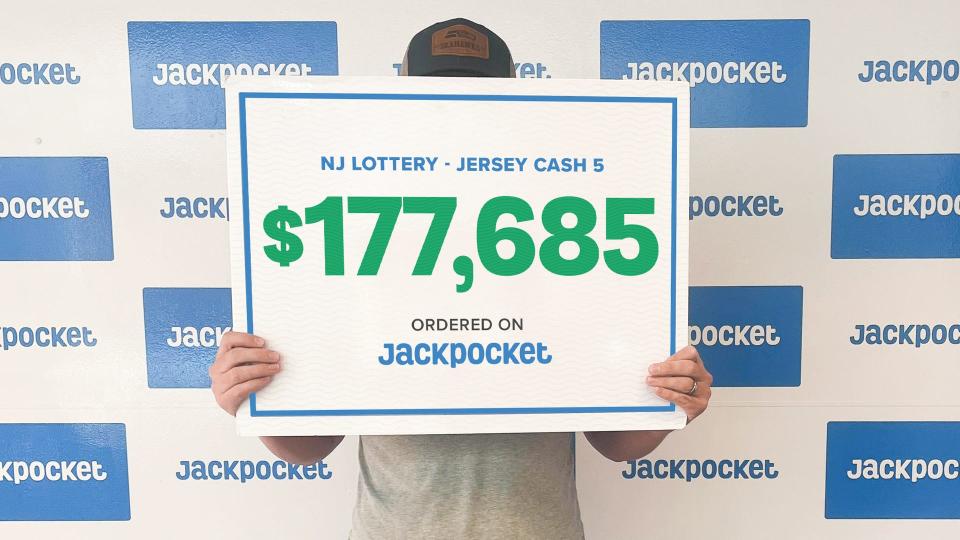 Dustin, a New Jersey Lottery winner, holds a check representing the $177,685 he won in the Jersey Cash 5 game on Oct. 2, 2023.