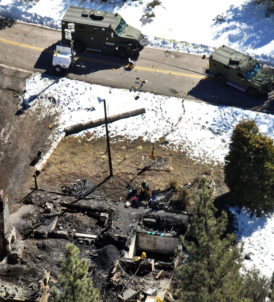 FILE - In this Wednesday, Feb. 13, 2013 aerial file photo, law enforcement authorities investigate the burnt-out cabin where quadruple-murder suspect Christopher Dorner died after barricading himself inside during a stand-off with police in the Angeles Oaks area of Big Bear, Calif. Authorities say Dorner killed four people. Eight Los Angeles police officers who mistakenly riddled a pickup truck with bullets during a manhunt for cop-turned-killer Christopher Dorner last year will be allowed to return to the field after they get additional training, Police Chief Charlie Beck said. (AP Photo/The Sun, John Valenzuela, File)