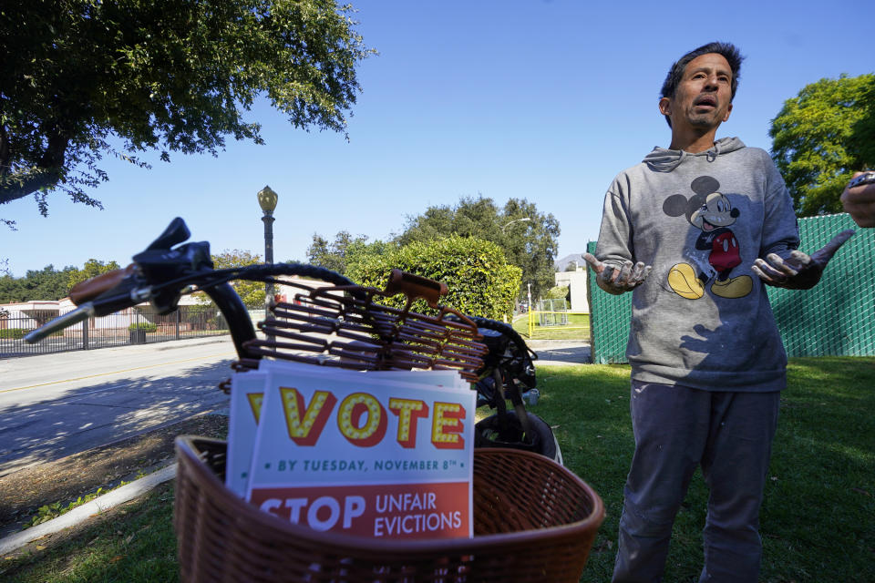 Pasadena resident and landlord, Joe Bautista, 47, a supporter of the Yes on Measure H! campaign, picks up campaign flyers at La Pintoresca Park in Pasadena, Calif., Saturday, Oct. 29, 2022. Cities across the country are pushing measures to stabilize or control rents when housing prices are skyrocketing. Voters from Orange County, Florida, and in several California cities are asking voters to approve ballot measures that would cap rent increases. (AP Photo/Damian Dovarganes)