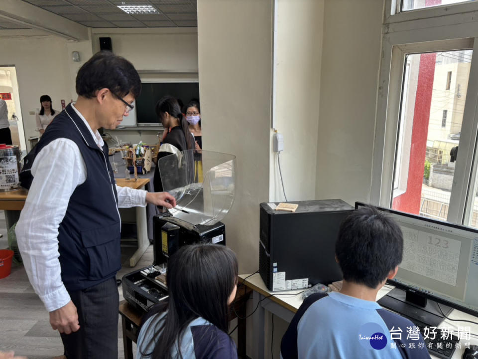 教育局長蔣偉民現場與學生合作DIY手機架。