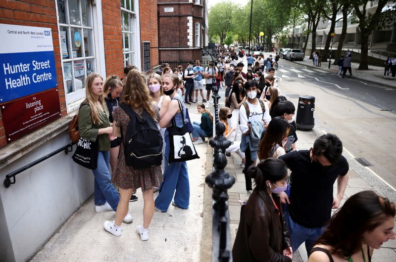 FILE PHOTO: People queue outside a vaccination centre for young people and students at the Hunter Street Health Centre, amid the coronavirus disease (COVID-19) outbreak, in London