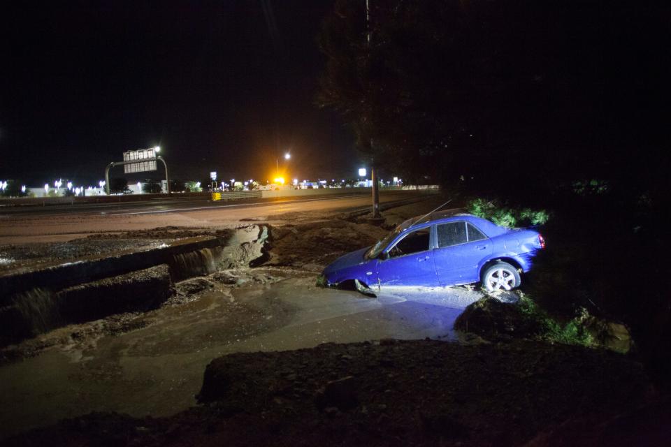 A car comes to rest between I-15 and the Dixie Convention Center after flood water moved barricades and washed away the shoulder Monday, Aug. 24, 2020.