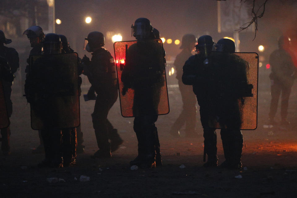 French riot police officers take position during a demonstration Saturday, Dec.1, 2018 in Paris. A protest against rising taxes and the high cost of living turned into a riot Saturday in Paris as police fired tear gas and water cannon in street battles with activists wearing the fluorescent yellow vests of a new movement. (AP Photo/Thibault Camus)