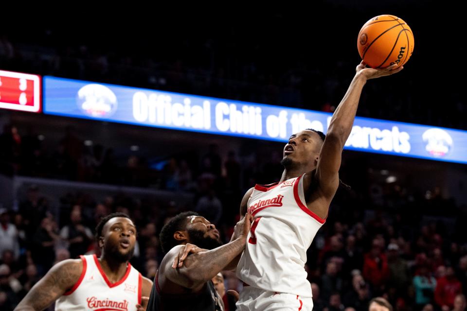 Cincinnati Bearcats guard Day Day Thomas (1) hits a layup as Oklahoma player John Hugley IV (1) fouls him in the second half of Saturday's 69-65 loss to the Sooners.