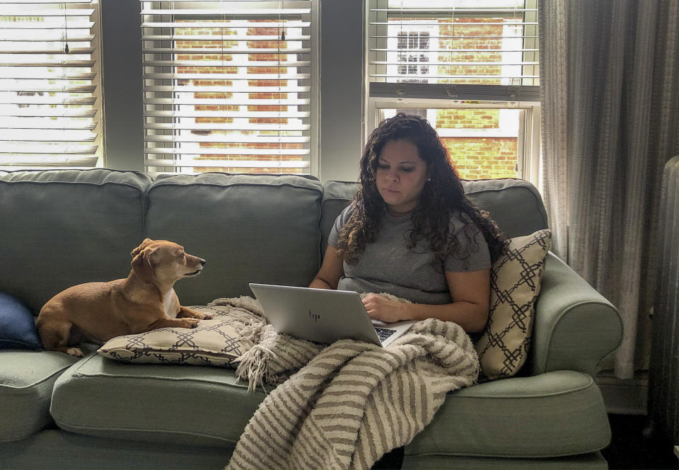In this March 27, 2020 photo, Vicktery Zimmerman works from her home in Chicago during the coronavirus-related order to shelter in place. A self-proclaimed extrovert, Zimmerman has come up with workarounds like video calls to help herself deal with the lack of social interaction. (Justin Zimmerman via AP)