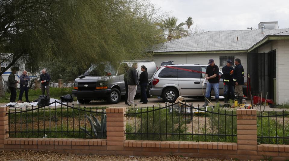 Phoenix Police Department and Fire Department investigators work at a home where skeletal remains were found Wednesday, Jan. 29, 2020, in Phoenix. The remains have been found at a house where authorities previously removed at least one child as part of a child abuse investigation in which both parents of that child were in custody, police said Wednesday. (AP Photo/Ross D. Franklin)