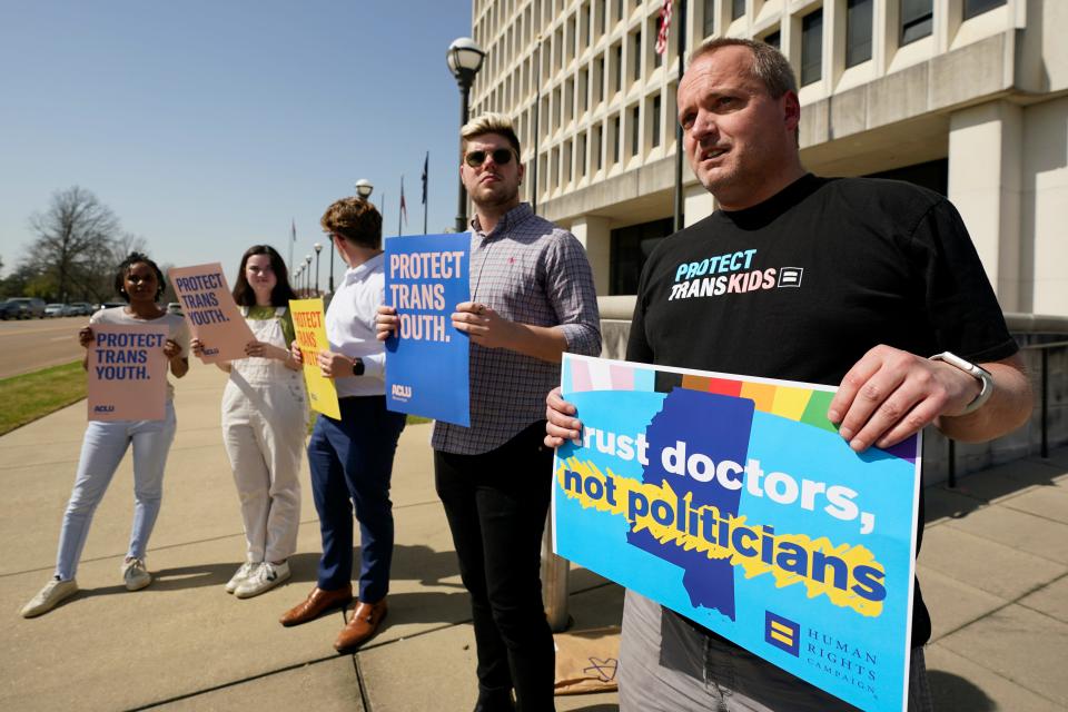 Rob Hill, state director of Human Rights Campaign Mississippi, right, says the new law signed by Republican Gov. Tate Reeves banning gender-affirming care in the state for anyone younger than 18, will "demonize and alienate transgender kids" who are already vulnerable, Tuesday, Feb. 28, 2023, outside the governor's offices in Jackson, Miss. Hill and a small group of protestors gathered outside the offices during the bill signing ceremony.