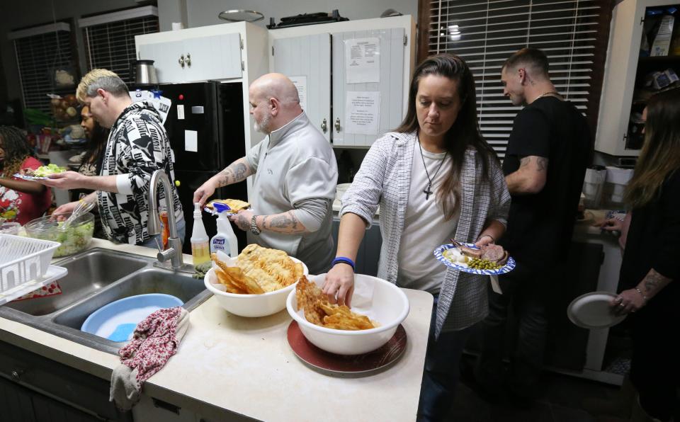 Dismas House residents get food during a traditional Icelandic Christmas dinner Wednesday, Dec. 20, 2023, at Dismas House in South Bend.