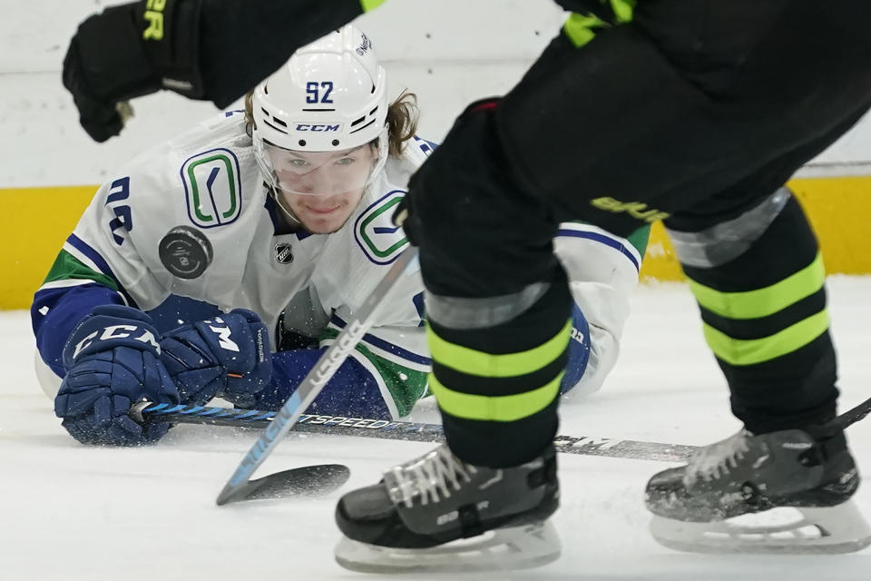 Vancouver Canucks right wing Vasily Podkolzin (92) watches the puck from the ice during the second period of the team's NHL hockey game against the Dallas Stars in Dallas, Saturday, March 25, 2023. (AP Photo/LM Otero)