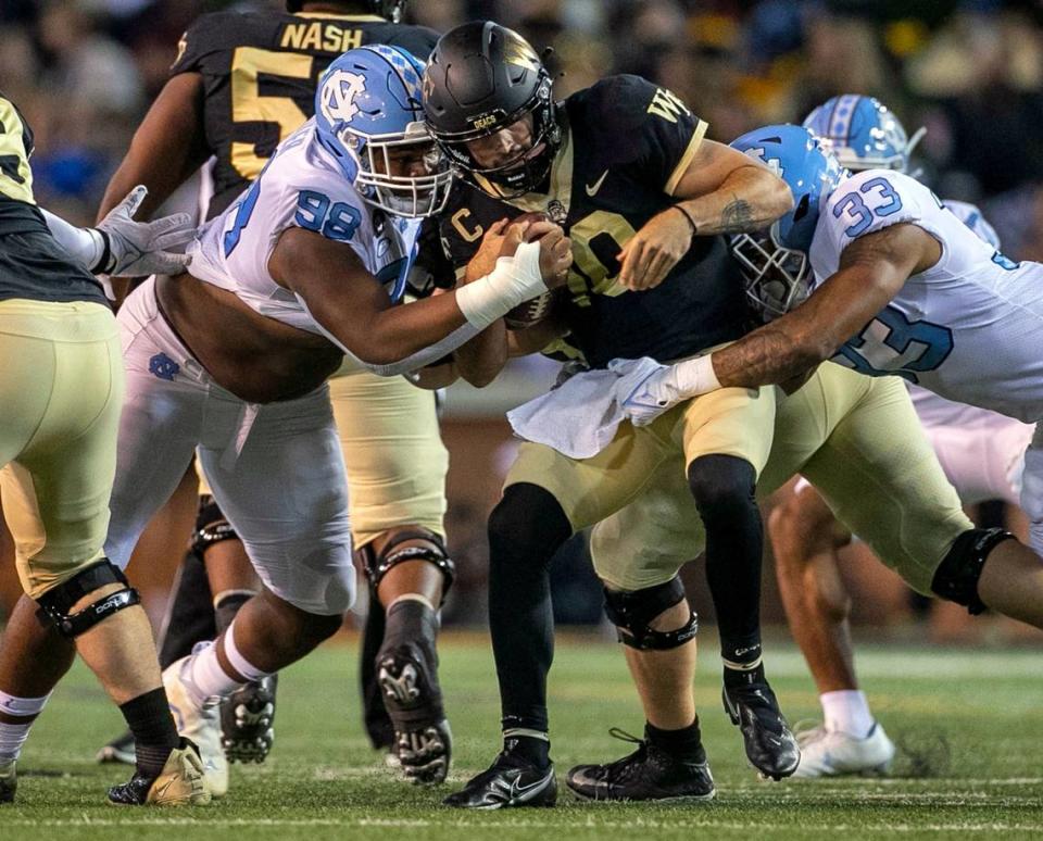 Wake Forest quarterback Sam Hartman (10) is sacked by North Carolina’s Cedric Gray (33) and Kevin Hester Jr. (98) in the first quarter on Saturday, November 12, 2022 at Truist Field in Winston-Salem, N.C.