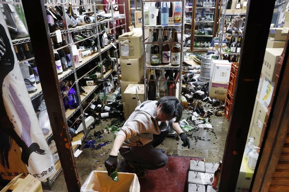 A liquor shop's manager clears the damaged bottles following an earthquake in Fukushima, northeastern Japan Saturday, Feb. 13, 2021. The Japan Meteorological Agency says a strong earthquake has hit off the coast of northeastern Japan, shaking Fukushima, Miyagi and other areas. (Jun Hirata/Kyodo News via AP)