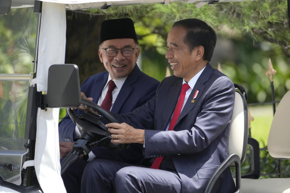 Indonesian President Joko Widodo, right, and Malaysian Prime Minister Anwar Ibrahim ride a golf cart during their meeting at the presidential palace in Bogor, West Java, Indonesia, Monday, Jan. 9, 2023. (AP Photo/Achmad Ibrahim)