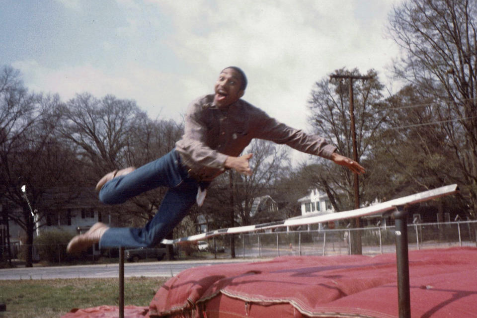 In this late 1980's photo provided by musician DJ Nabs, his childhood friend, Alton Lucas, jumps in a field at Durham High School in Durham, N.C. As a teenager, Alton Lucas believed basketball or music would pluck him out of North Carolina and take him around the world. (Courtesy DJ Nabs via AP)