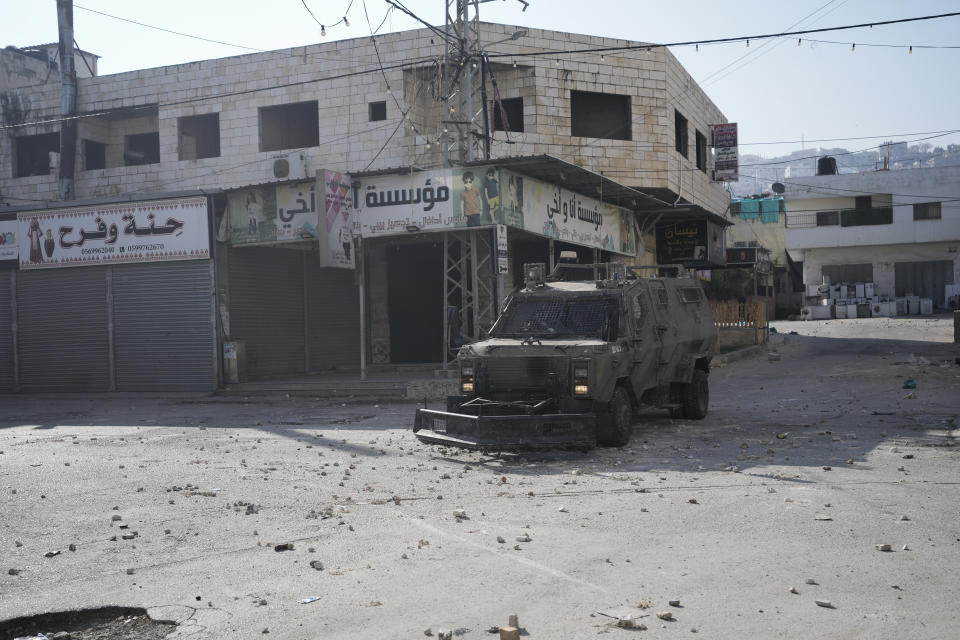 Israeli military vehicles are seen during an army raid in the West Bank city of Jenin, Thursday, Jan. 26, 2023. Israeli forces killed at least nine Palestinians, including a 60-year-old woman, and wounded several others during a raid in a flashpoint area of the occupied West Bank on Thursday, Palestinian health officials said, in one of the deadliest days in months of unrest. The Israeli military said it was conducting an operation to arrest a militant grouping linked to the Palestinian Islamic Jihad, which has major foothold in the camp. A gun battle erupted, during which the military said it was targeting militants involved in planning and carrying out attacks on Israelis. (AP Photo/Majdi Mohammed)