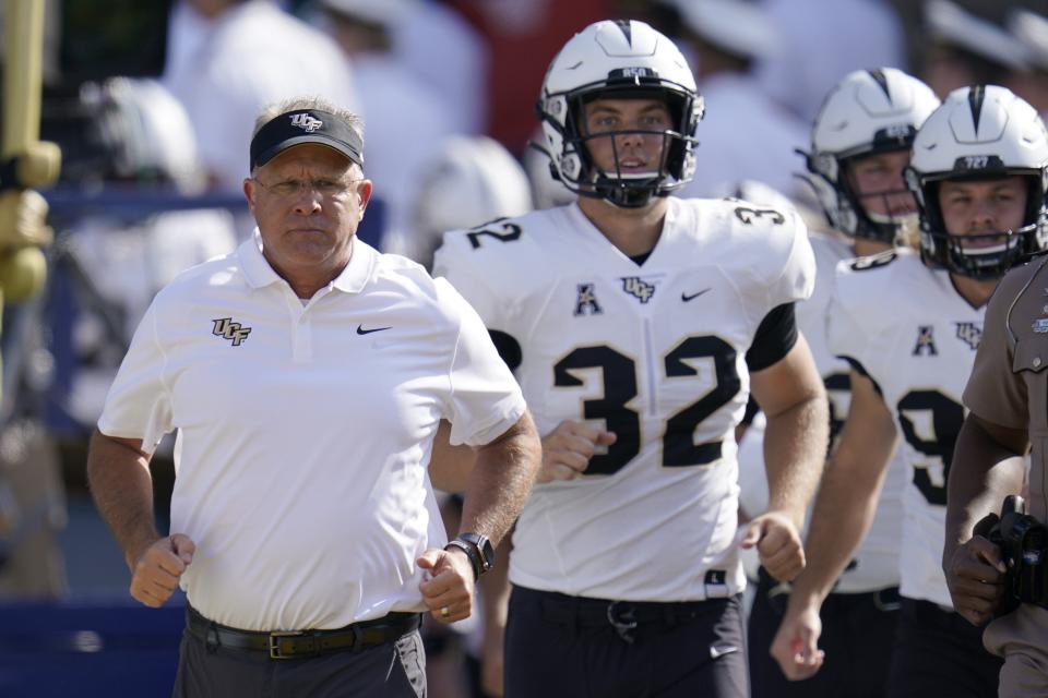 UCF head coach Gus Malzahn, left, runs on the field with long snapper Alex Ward (32) prior to an NCAA college football game against Navy, Saturday, Oct. 2, 2021, in Annapolis, Md. (AP Photo/Julio Cortez)