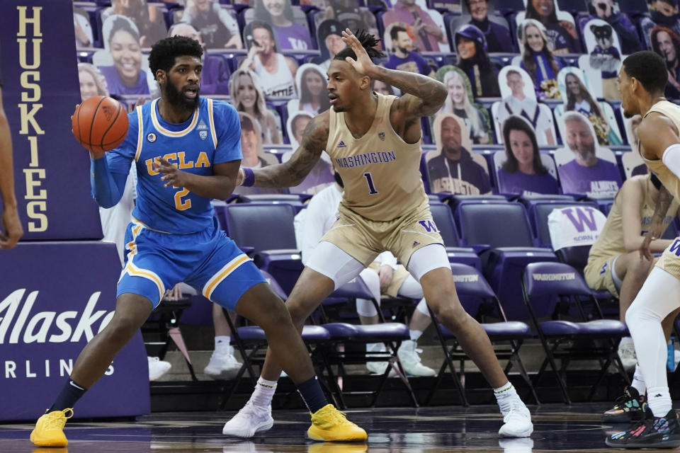 UCLA forward Cody Riley (2) tries to pass the ball around the defense of Washington forward Nate Roberts (1) during the first half of an NCAA college basketball game Saturday, Feb. 13, 2021, in Seattle. (AP Photo/Ted S. Warren)
