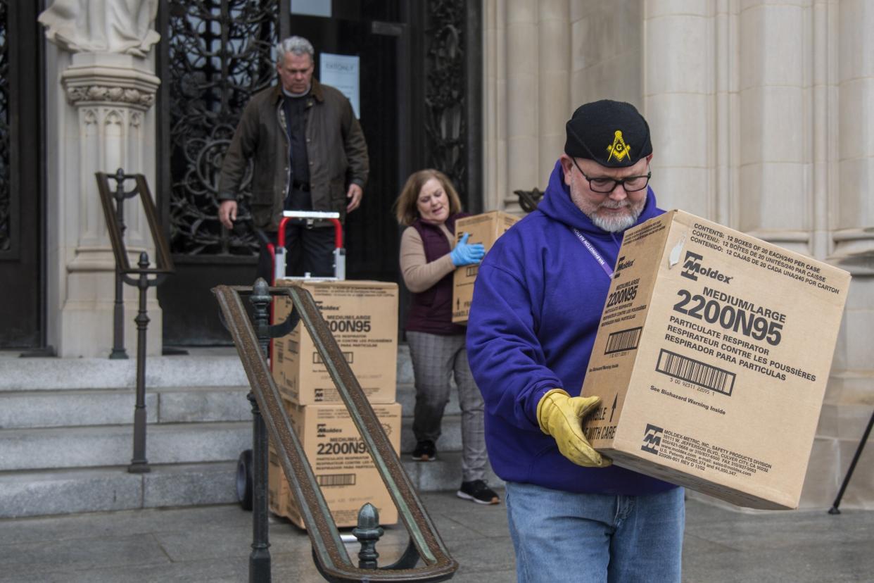 People transport boxes of N95 respirator masks out of the Washington National Cathedral on March 25, 2020. (Photo: The Washington Post via Getty Images)