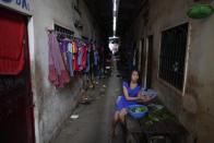 Una mujer prepara la comida en el edificio donde los trabajadores textiles viven en Phnom Penh. (Reuters/Damir Sagolj).