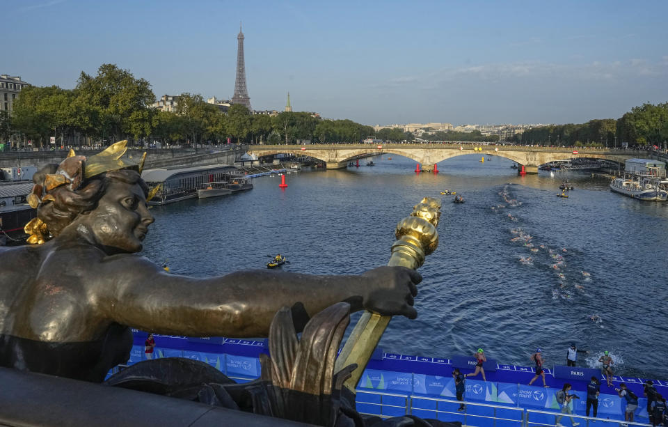 Athletes dive and swim in the Seine river from the Alexander III bridge on the first leg of the women's triathlon test event for the Paris 2024 Olympics Games in Paris, Thursday, Aug. 17, 2023. In 2024. (AP Photo/Michel Euler, File)