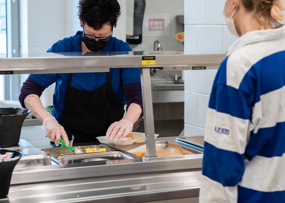 Food service worker Michele Weisel serves up scrambled eggs and pancakes during lunch period at Quakertown Community High School on Wednesday, October 13, 2021.