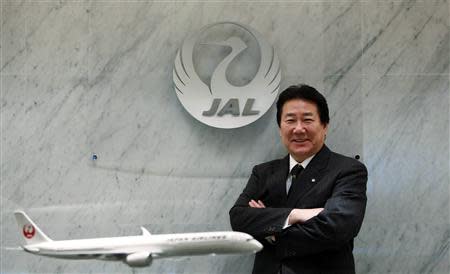 Yoshiharu Ueki, president of Japan Airlines, poses for photographs with a model of JAL's Airbus A350-900 after an interview with Reuters at its headquarters in Tokyo October 24, 2013. REUTERS/Yuya Shino