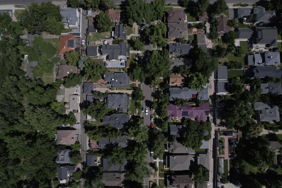 Mansions dot a tree-lined street in the Country Club neighborhood in Denver, July 24, 2023. Temperatures are hotter in America's low-income neighborhoods like the Denver suburb of Globeville, where many residents are low-income and people of color living in stretches of concrete that hold heat like a cast-iron skillet. Comparatively, in wealthy neighborhoods such as Country Club, mansions pocket a sea of vegetation which cools the area. (AP Photo/Brittany Peterson)