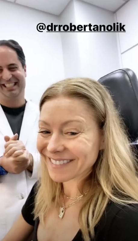 Close-up of Kelly smiling with a man smiling behind her