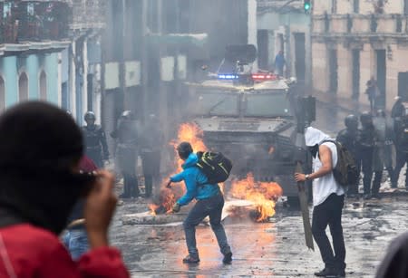 Demonstrators clash with riot police during protests after Ecuador's President Lenin Moreno's government ended four-decade-old fuel subsidies, in Quito