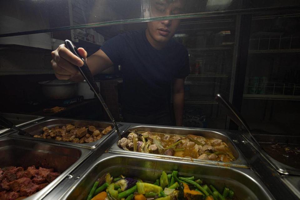 Matt Cardano explica las diferentes comidas filipinas en el buffet del Aklan Philippine Buffet en Miami, Florida, el lunes 10 de octubre de 2022.