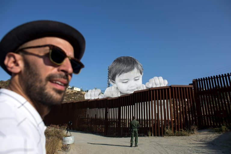 JR is pictured near his artwork on the US-Mexico border in Tecate on September 6, 2017