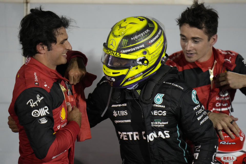 Mercedes driver Lewis Hamilton of Britain, centre, greets Ferrari driver Carlos Sainz of Spain, left, and Ferrari driver Charles Leclerc of Monaco after the Formula One Bahrain Grand Prix it in Sakhir, Bahrain, Sunday, March 20, 2022. (AP Photo/Hassan Ammar)