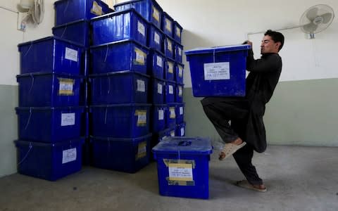 Afghan election commission worker prepares ballot boxes and election material to send to the polling stations at a warehouse in Jalalabad - Credit: Reuters