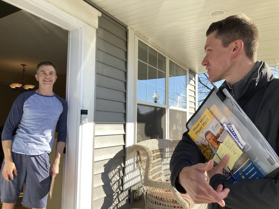 Matt Norris, a Democratic candidate for the Minnesota House, gets a pledge of support from voter Grant Cravens in Blaine, Minn., on Wednesday, Oct. 26, 2022. (AP Photo/Steve Karnowski)