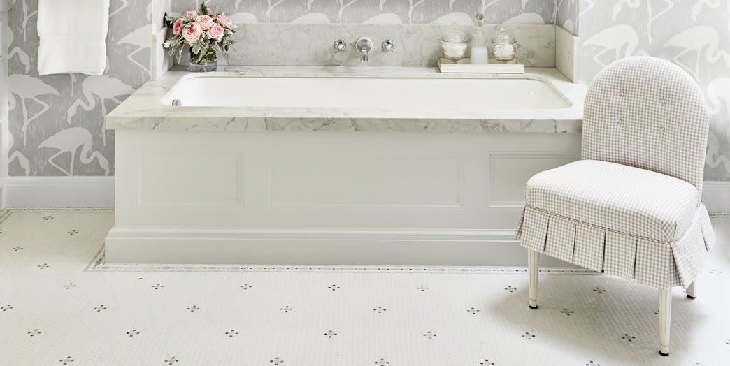 fun flamingo wallpaper in subtle gray and white on the walls around a soaking tub in a white bathroom