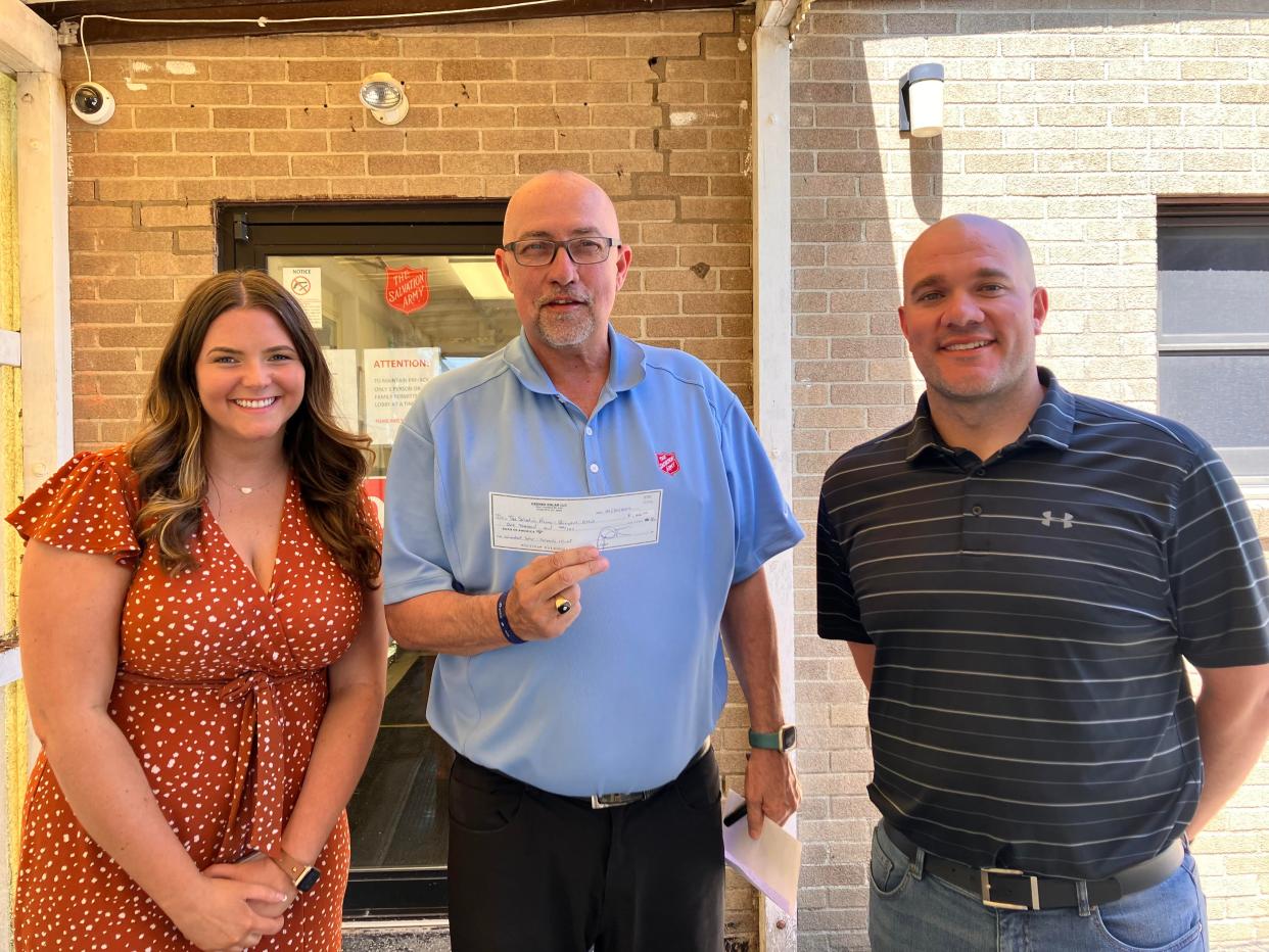 One of the Wombat Solar grant recipients was the Bucyrus Salvation Army. Major Tom Grace, center, said the organization applied in order to help families that were out of power and unable to access meals. Grace received the funds from Leah Cordy, left, and Wes Smith of Wombat.