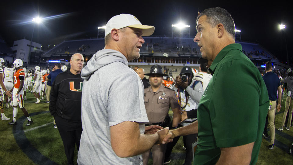 Georgia Tech interim head coach Brent Key, front left, shake hands with Miami head coach Mario Cristobal, right, after an NCAA college football game Saturday, Nov. 12, 2022, in Atlanta. (AP Photo/Hakim Wright Sr.)