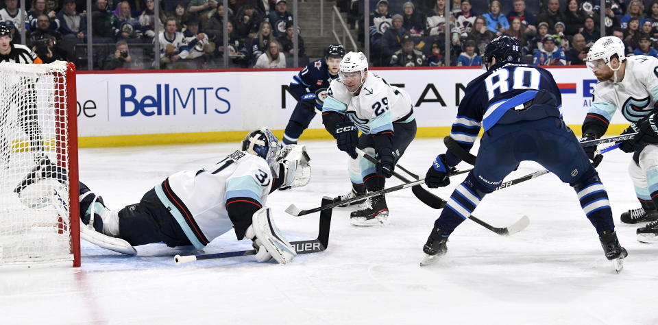 Seattle Kraken goaltender Philipp Grubauer (31) makes as save on Winnipeg Jets' Pierre-Luc Dubois (80) during the second period of an NHL game in Winnipeg, Manitoba on Tuesday Feb. 14, 2023. (Fred Greenslade/The Canadian Press via AP)