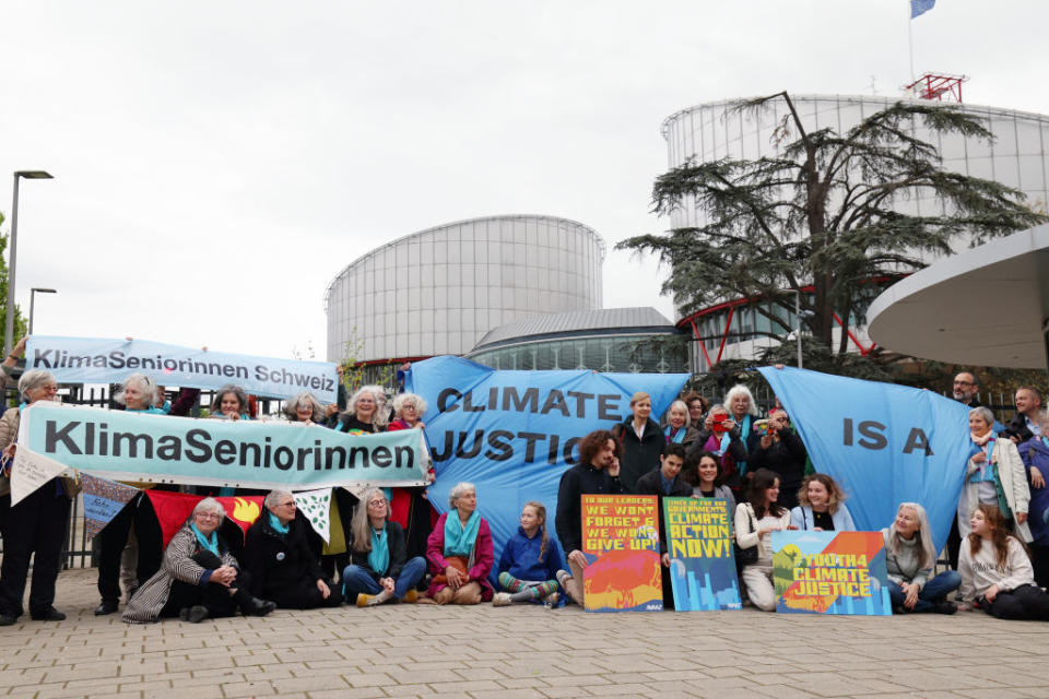 Protesters hold placards, including one with the KlimaSeniorinnen group name, during a rally before the European Court of Human Rights. <span class="copyright">Frederick Florin—AFP/Getty Images</span>