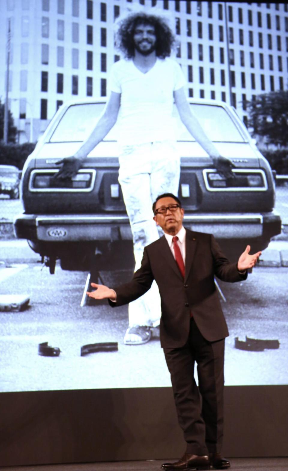 Toyota President Akio Toyoda showing off an old photo of a younger Pratt, working on a Toyota car. <span class="inline-image-credit">(AP Photo/Eugene Hoshiko)</span>