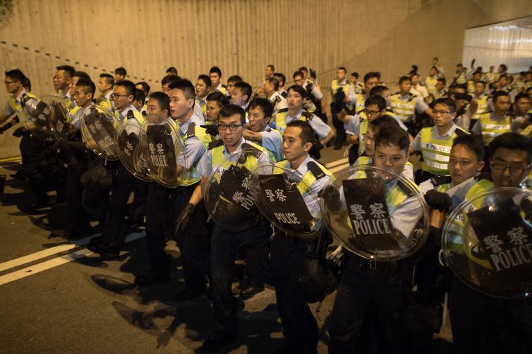 Police march towards pro-democracy protesters outside the central government offices in Hong Kong on October 15, 2014