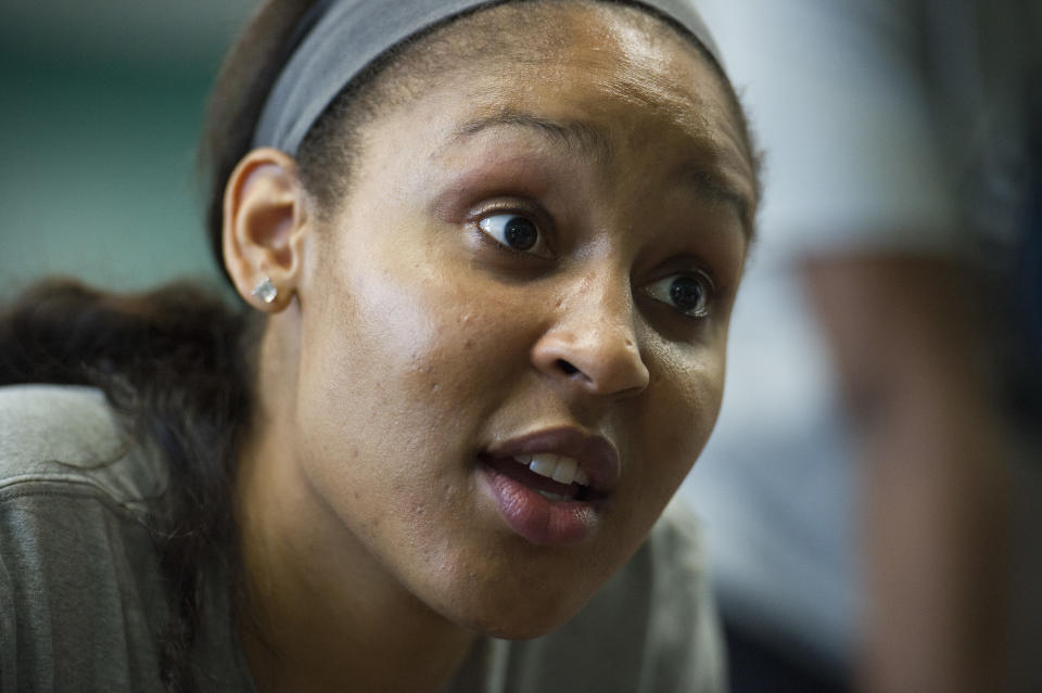 WNBA Champion Minnesota Lynx forward Maya Moore talks with a student after washing his feet at Payne Elementary School in Washington, Wednesday, June 6, 2018. Payne Elementary has the highest homeless student population in the district. (AP Photo/Cliff Owen)