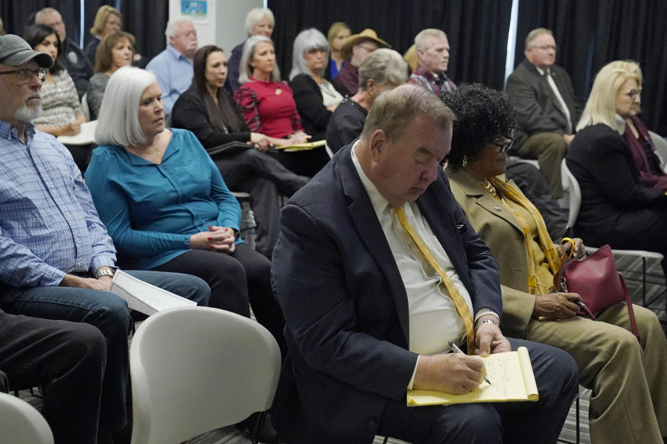 Mark Henricksen, front, attorney for Scott Eizember, takes notes during a clemency hearing for Eizember before the Pardon and Parole Board, Wednesday, Dec. 7, 2022, in Oklahoma City. (AP Photo/Sue Ogrocki)