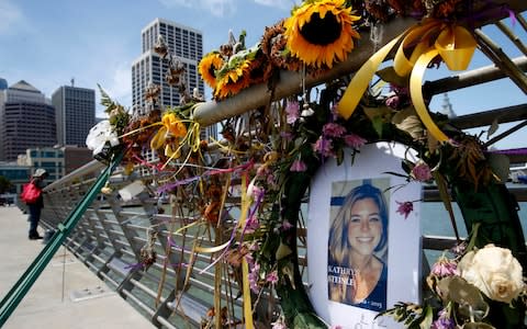 Flowers and a portrait of Kate Steinle were placed at a memorial site on Pier 14 in San Francisco - Credit: AP