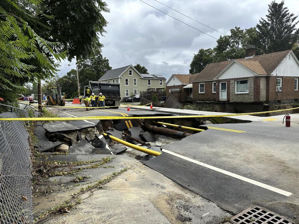 Road crews assess a sinkhole on Chestnut Street in Leominster, Mass., Tuesday, Sept. 12, 2023. Parts of Massachusetts and Rhode Island were flooded by heavy rain Monday night. (AP Photo/Michael Casey)