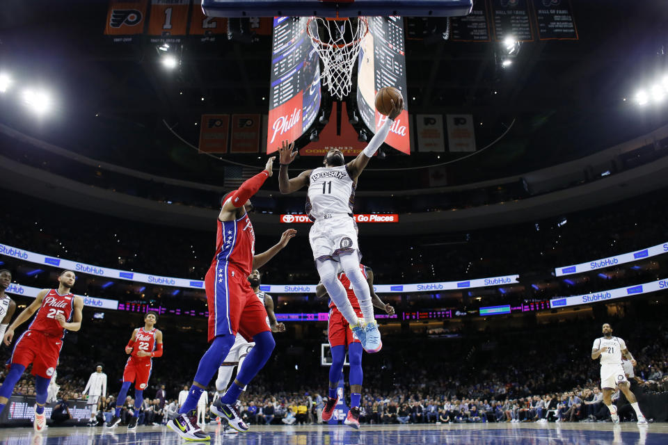 Brooklyn Nets' Kyrie Irving, right, goes up for a shot against Philadelphia 76ers' Tobias Harris during the first half of an NBA basketball game, Wednesday, Jan. 15, 2020, in Philadelphia. (AP Photo/Matt Slocum)